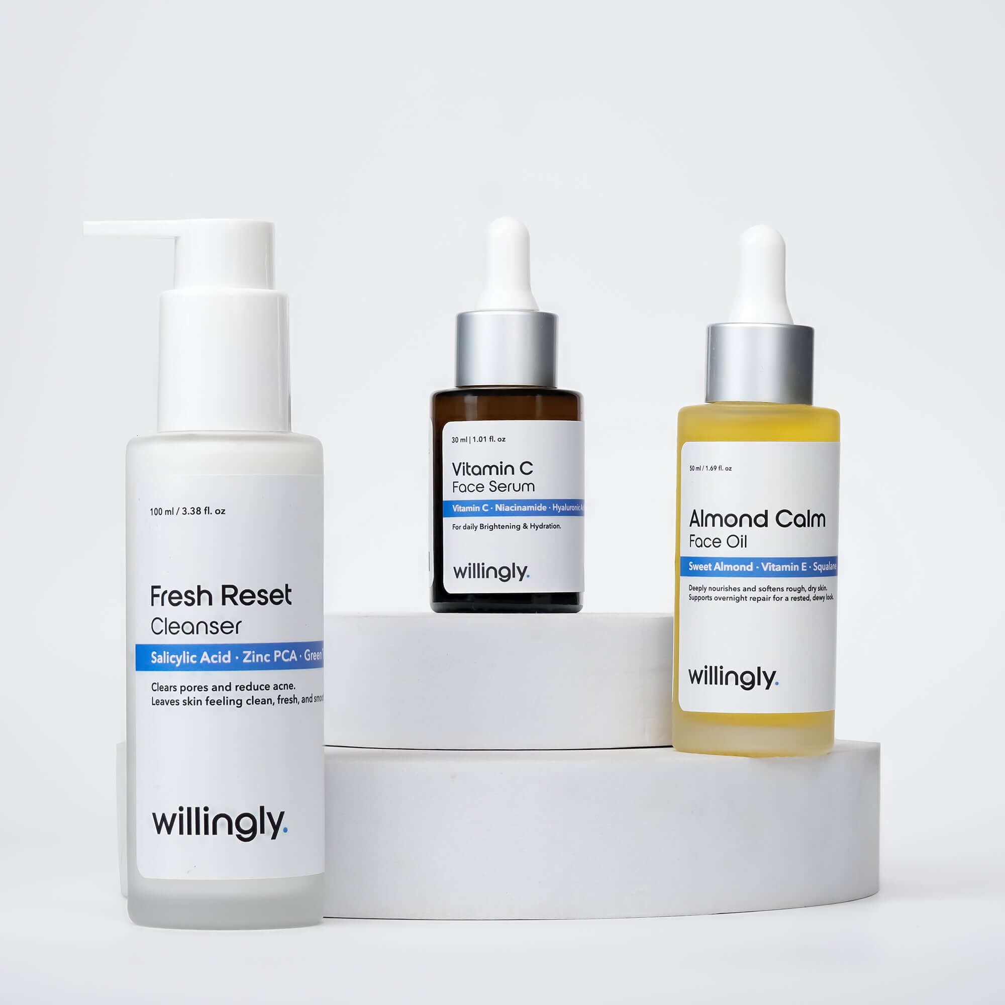 Willingly Clear Glow Set with Fresh Reset Cleanser, Vitamin C Face Serum, and Almond Calm Face Oil on white marble display