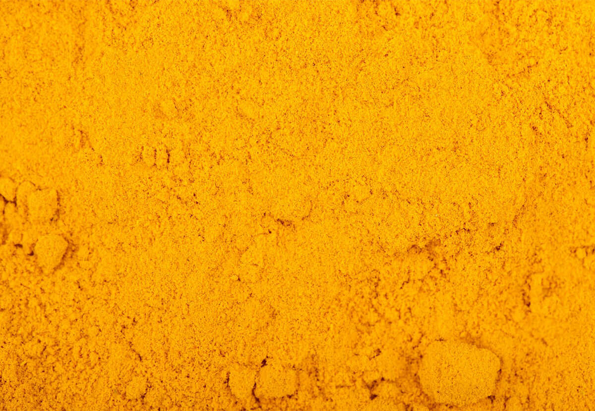 Bright yellow turmeric powder close-up, symbolizing natural skin benefits