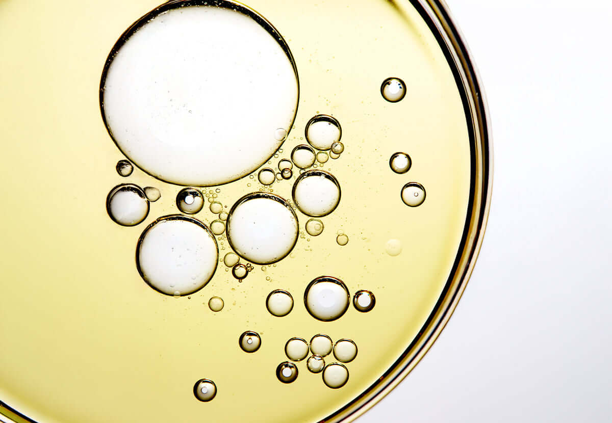 Golden jojoba oil droplets, representing deep nourishment and natural skin compatibility