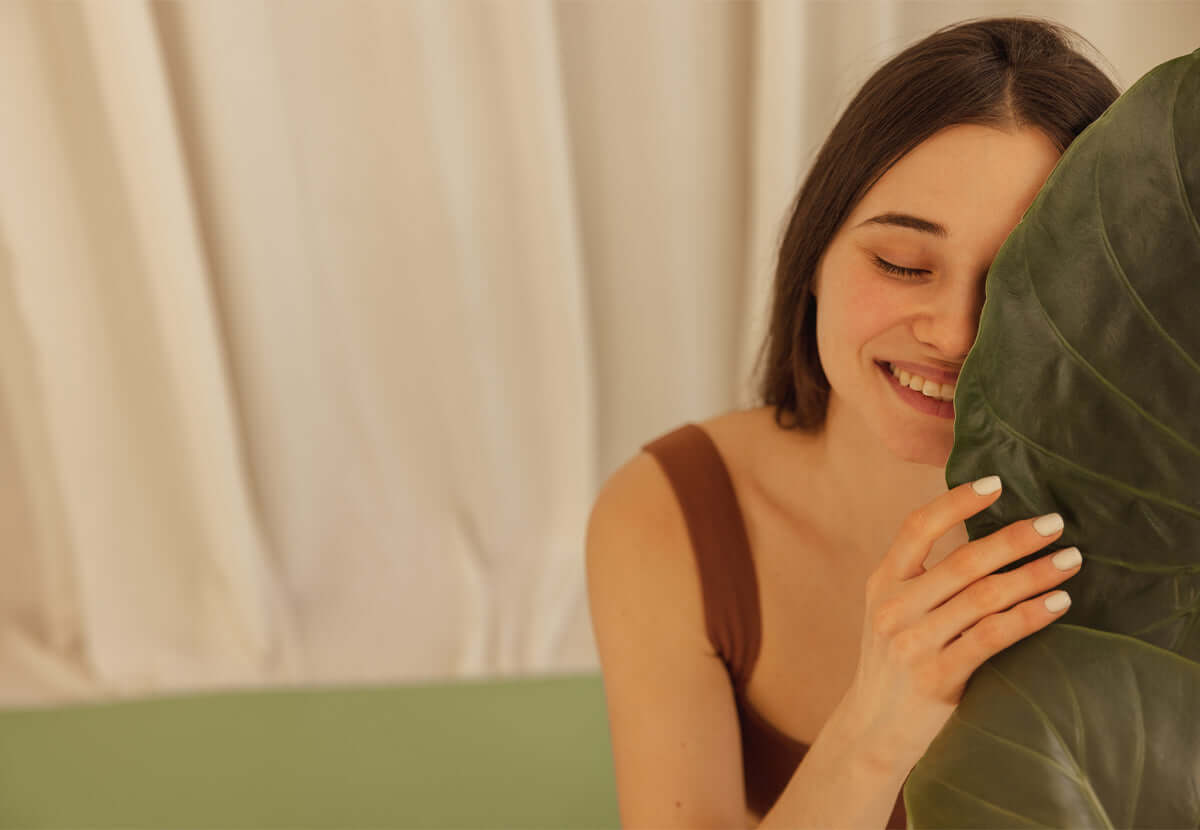 Woman applying skincare in front of a mirror, representing self-care and product education