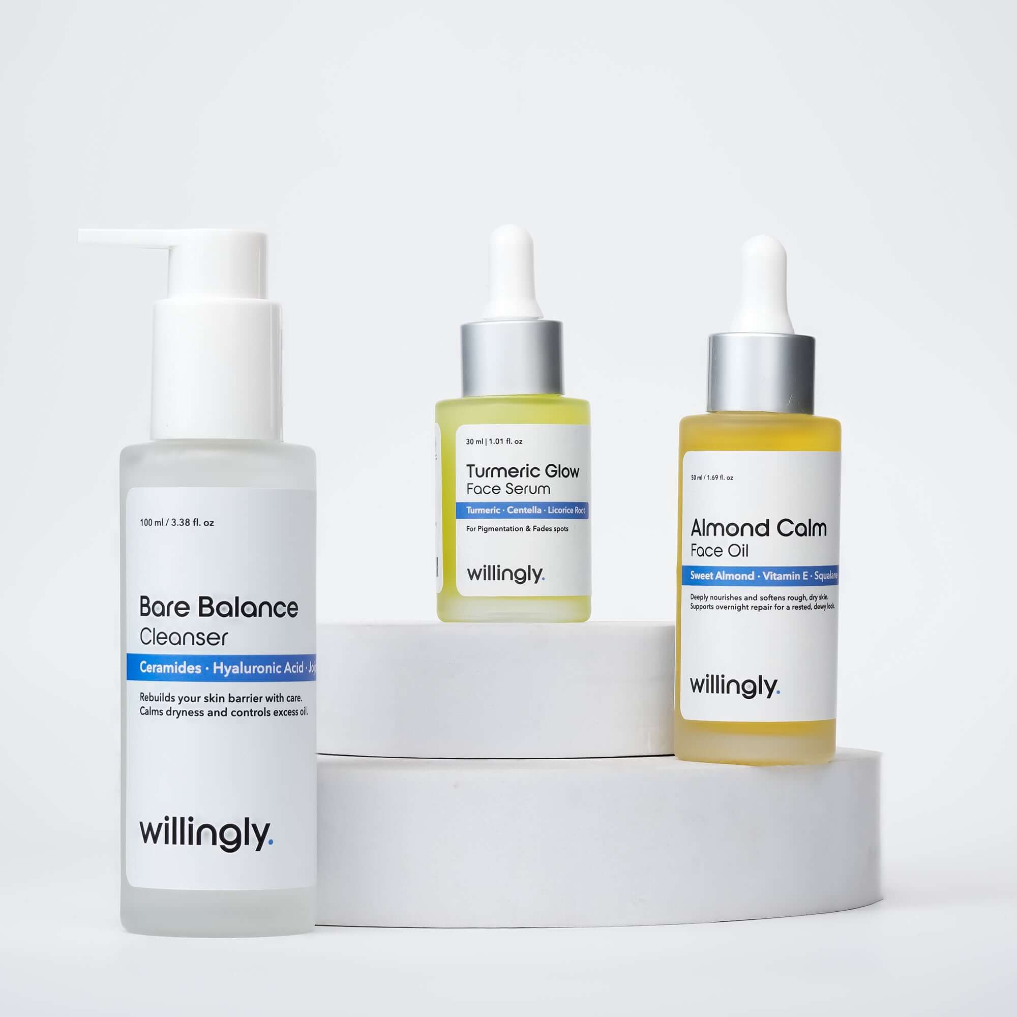 Willingly Barrier Care Tria with Bare Balance Cleanser, Turmeric Glow Face Serum, and Almond Calm Face Oil on white marble display