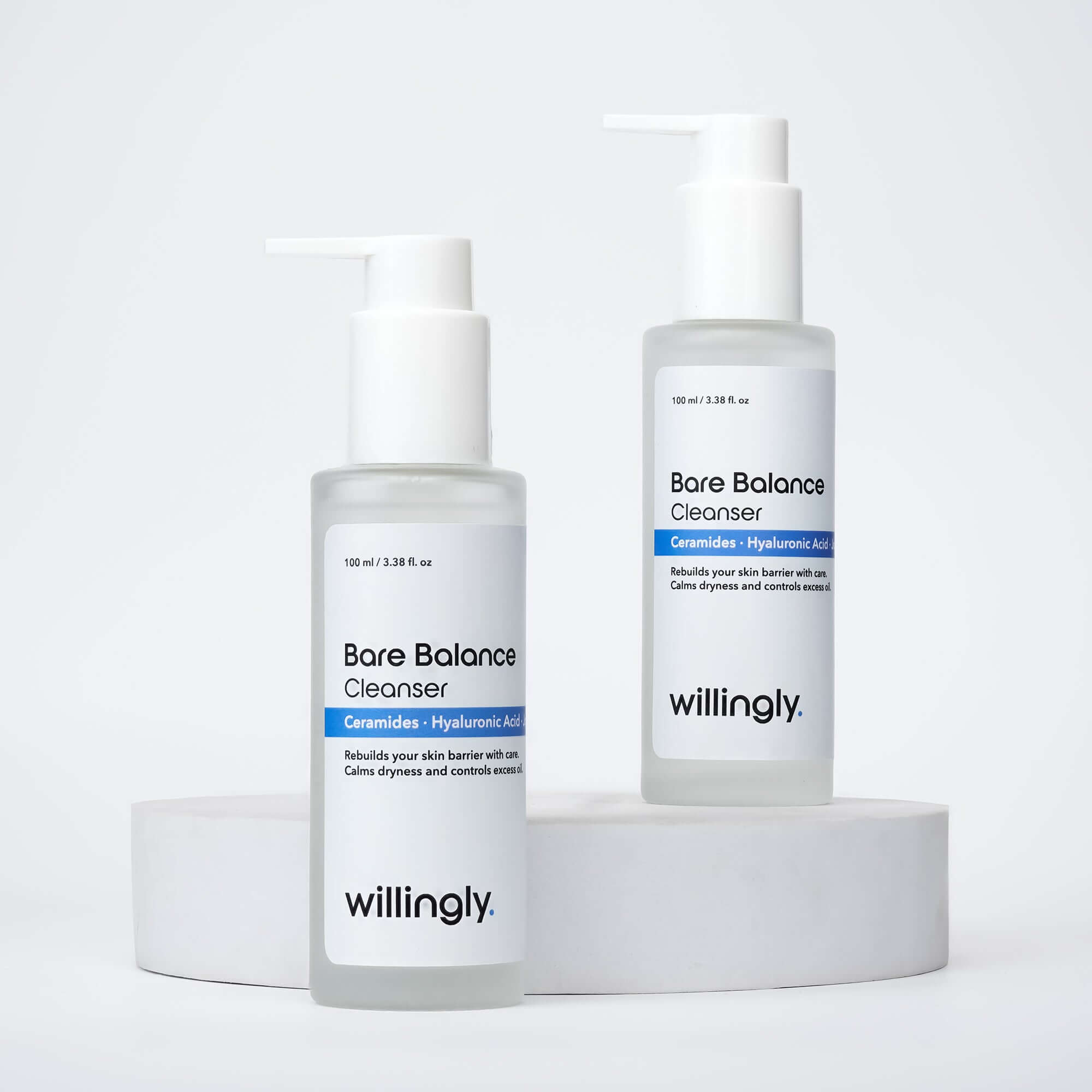 Two bottles of Willingly Bare Balance Cleanser placed on white marble blocks for product display