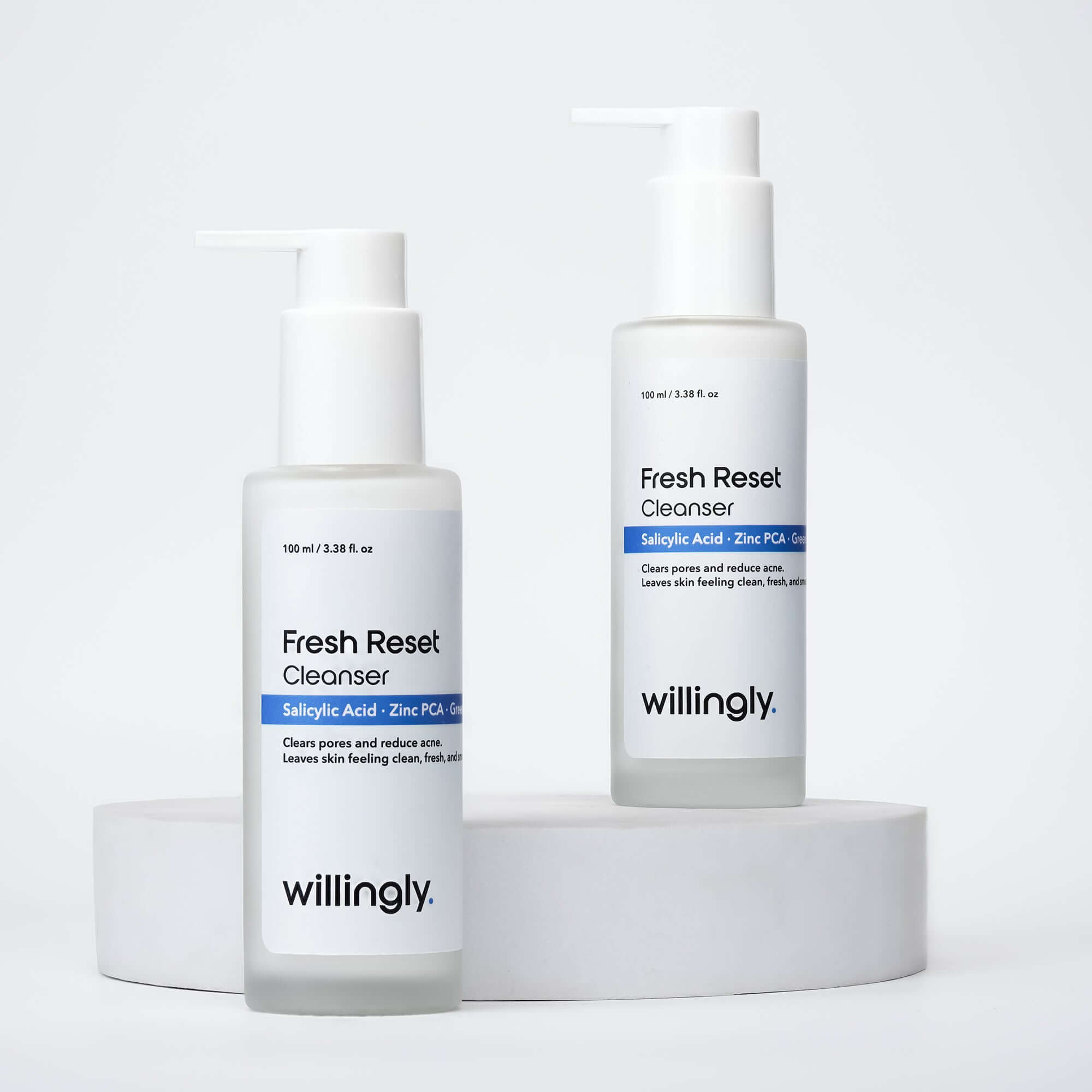 Two bottles of Willingly Fresh Reset Cleanser placed on white marble blocks for product display