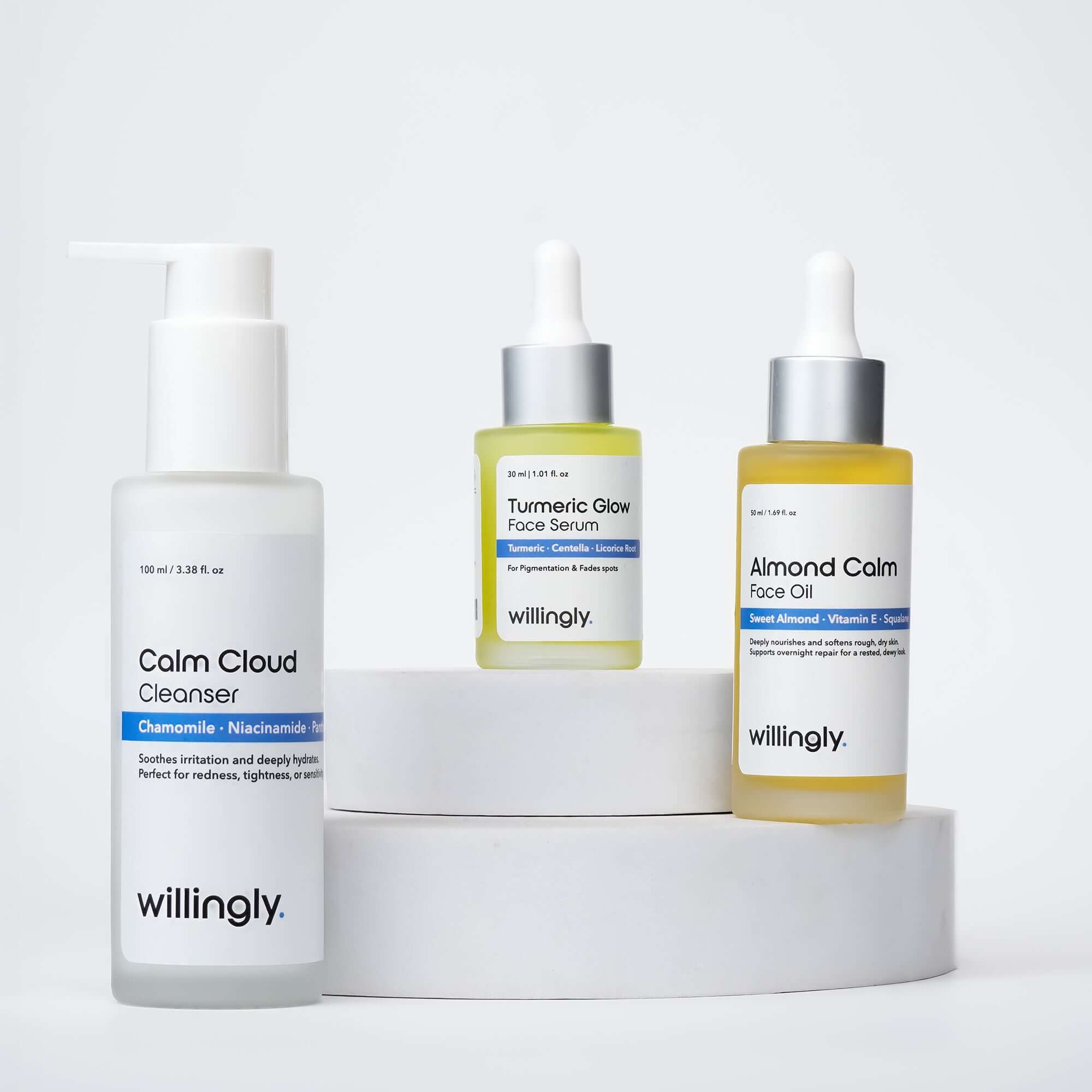 Willingly Soothing Essentials Kit with Calm Cloud Cleanser, Turmeric Glow Face Serum, and Almond Calm Face Oil on white marble display